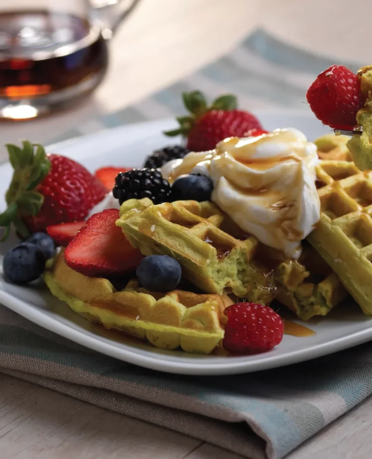 avocado waffles with blueberries and strawberries and whip cream on top