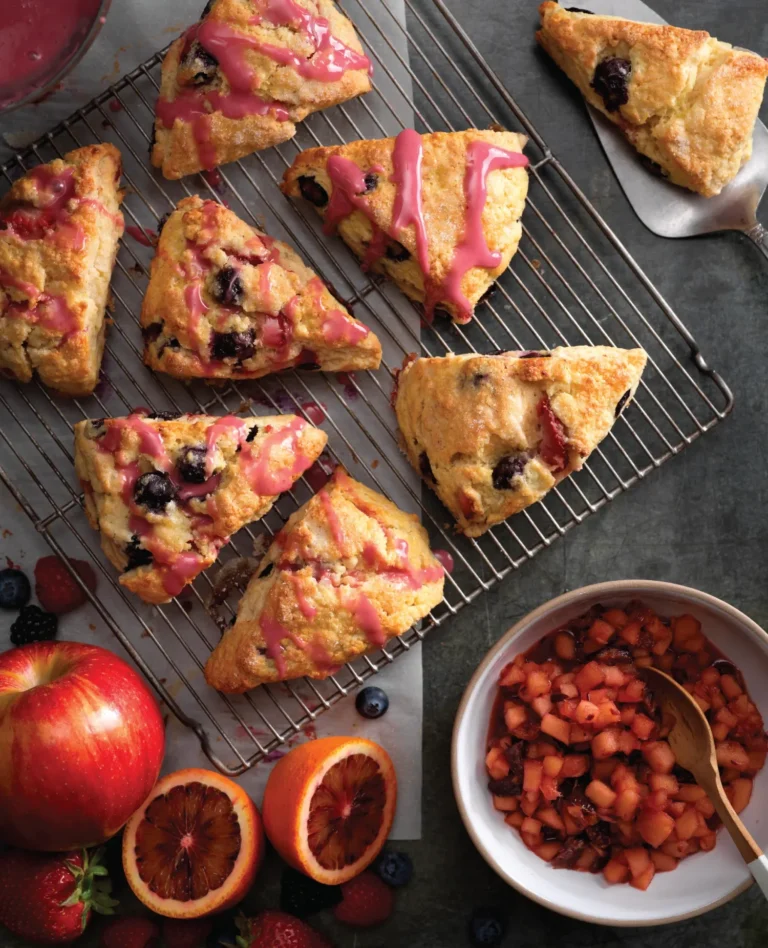 blood orange scones with blueberries and glaze on a wire cooling rack
