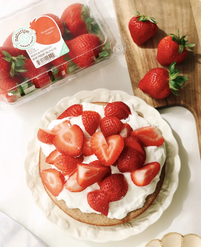 strawberry shortcake with whipped cream and strawberries on top, next to a package of Naturipe strawberries