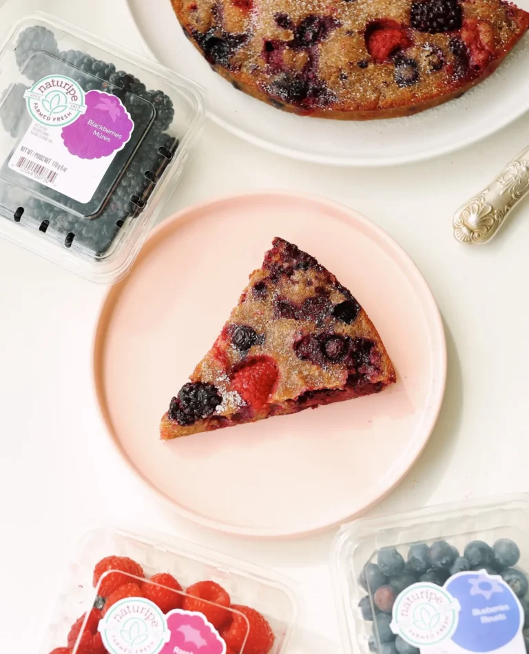 torte cake with raspberries, blackberries, and blueberries on a plate on table
