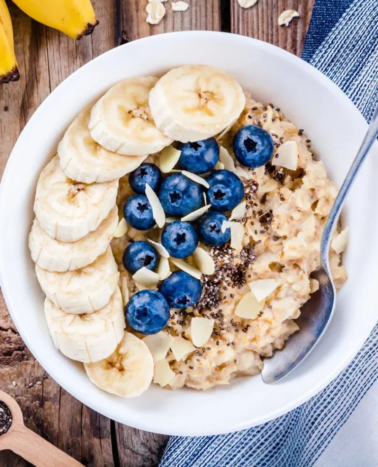 bowl of warm oatmeal with blueberries and banana slices inside